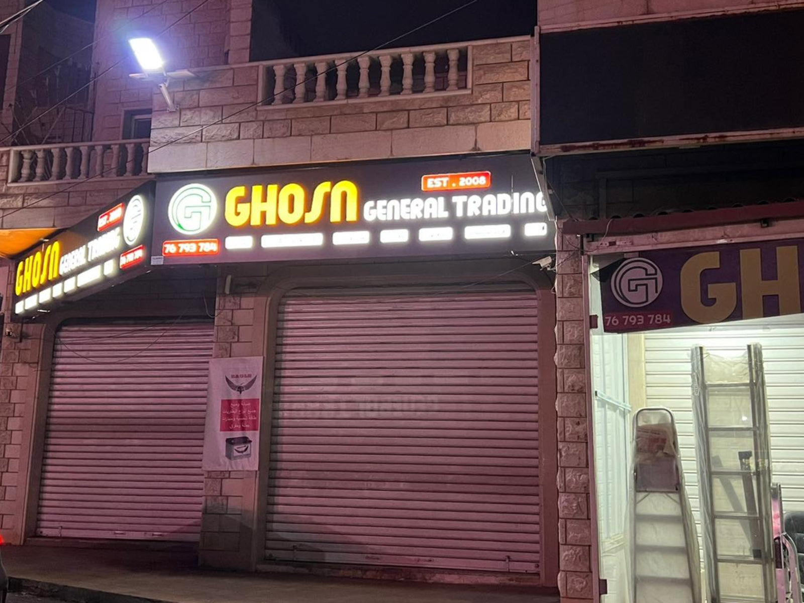 Closed store front with 'Ghosn' sign at night